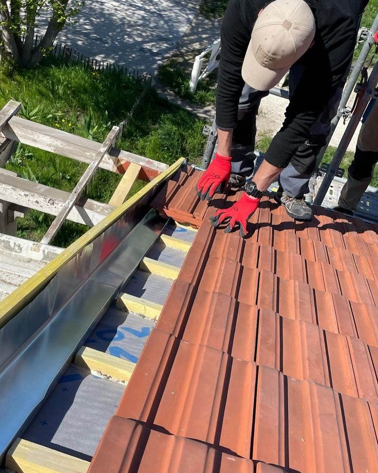 Couvreur Daumas Rénovation posant des tuiles sur une toiture